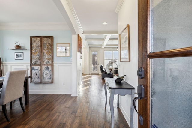 entrance foyer featuring coffered ceiling, dark wood-type flooring, wainscoting, beamed ceiling, and a decorative wall