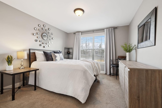 bedroom with baseboards and light carpet