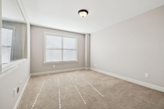 carpeted spare room with baseboards