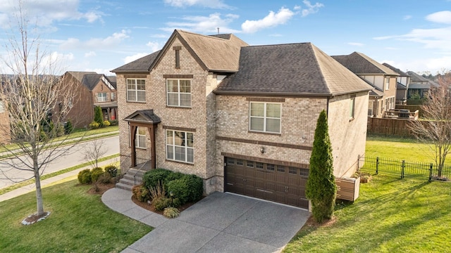 view of front facade with a front yard, fence, driveway, a garage, and brick siding