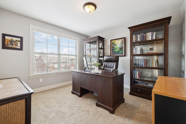 office space featuring light carpet and baseboards