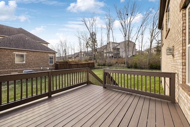 wooden terrace with a lawn and fence