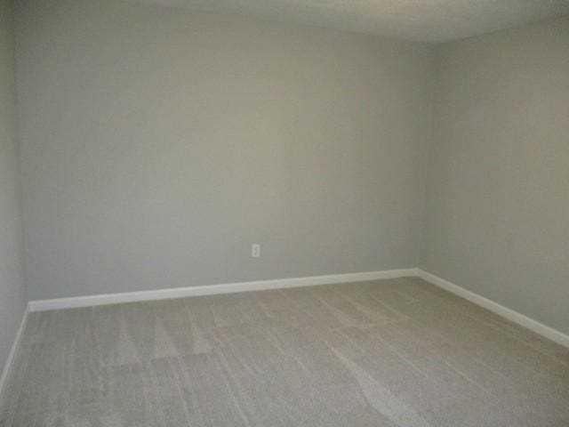 empty room with light colored carpet and baseboards