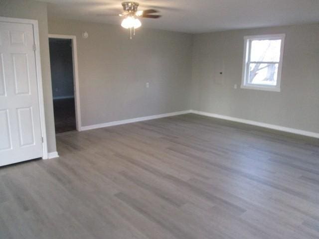 unfurnished room featuring wood finished floors, baseboards, and ceiling fan