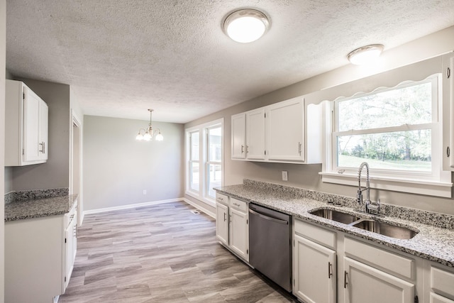 kitchen with dishwasher, a chandelier, a sink, and a textured ceiling