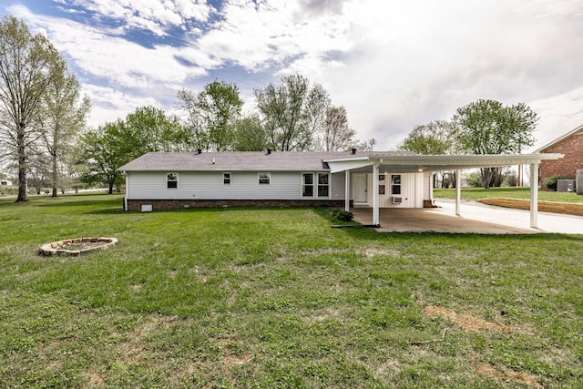 back of property with a lawn and a carport