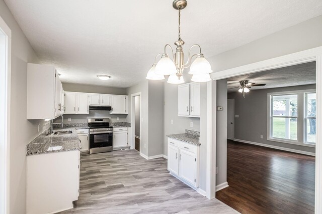 kitchen with light stone counters, under cabinet range hood, stainless steel electric range oven, and light wood-style floors