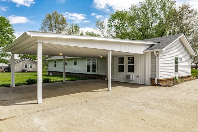 view of front of house with a front yard, a shingled roof, a carport, and concrete driveway