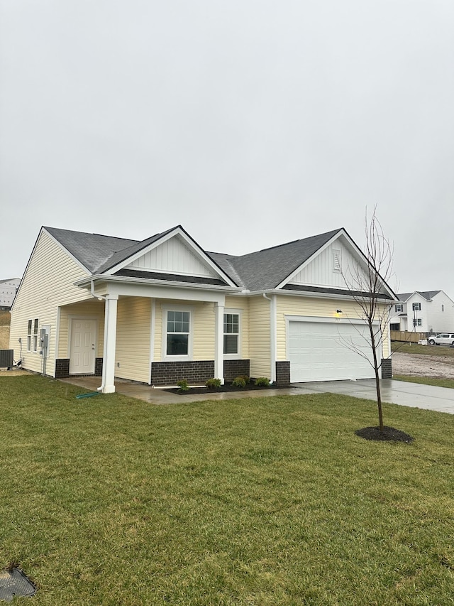 view of front of house with driveway, a front lawn, central AC, a garage, and brick siding