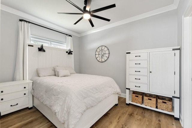 bedroom featuring ceiling fan, wood finished floors, and ornamental molding