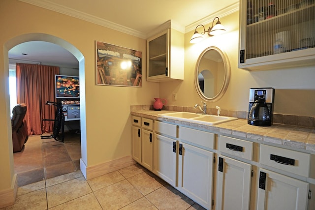 bathroom featuring tile patterned floors, baseboards, ornamental molding, and vanity