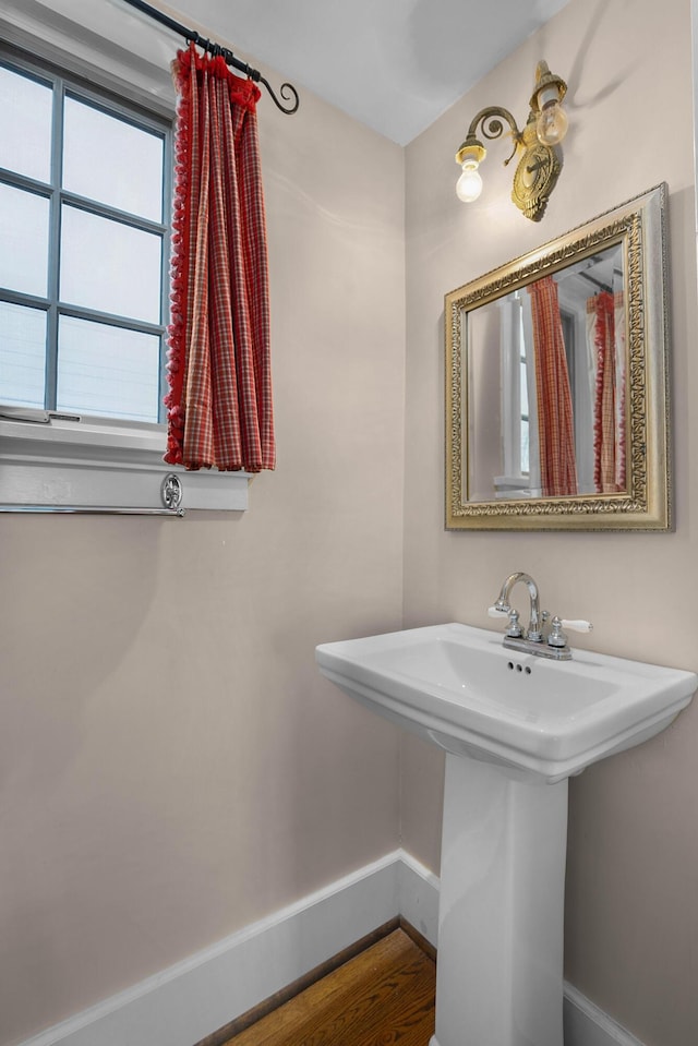 bathroom featuring a sink, baseboards, and wood finished floors