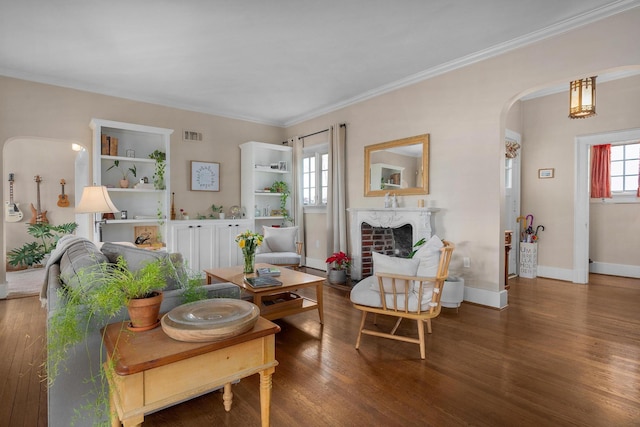 living room with arched walkways, ornamental molding, baseboards, and wood finished floors