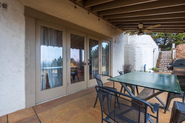 view of patio featuring outdoor dining space, stairs, french doors, and a ceiling fan