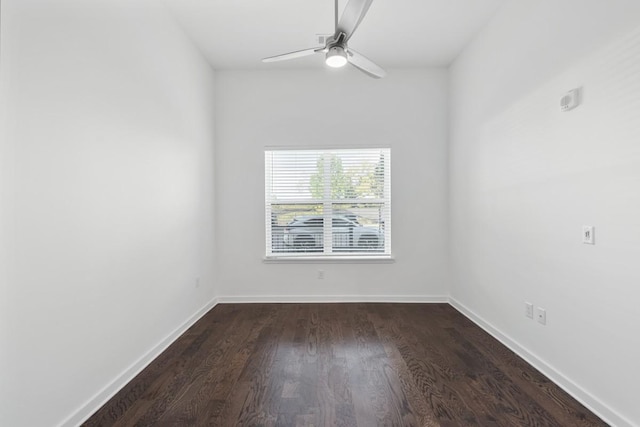 unfurnished room featuring a ceiling fan, baseboards, and dark wood-style flooring