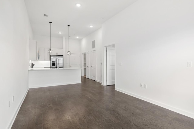 unfurnished living room featuring dark wood-type flooring, recessed lighting, baseboards, and visible vents