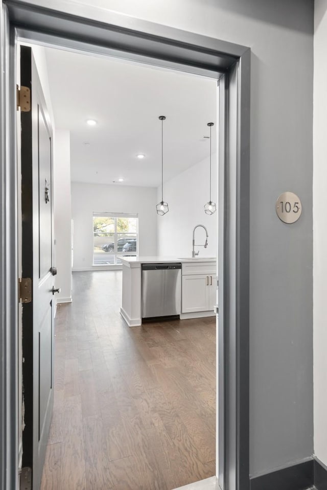 hall featuring recessed lighting, wood finished floors, and a sink