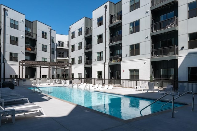 view of swimming pool with a patio area and fence