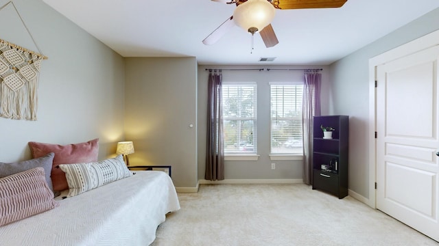 bedroom featuring a ceiling fan, baseboards, visible vents, and light carpet