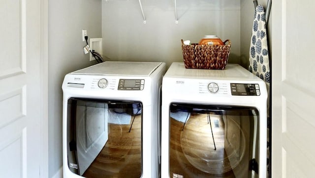 clothes washing area featuring separate washer and dryer