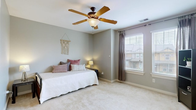 bedroom with visible vents, baseboards, light carpet, and a ceiling fan