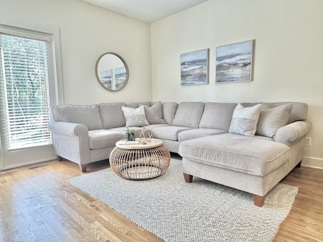 living room with visible vents, baseboards, and wood finished floors