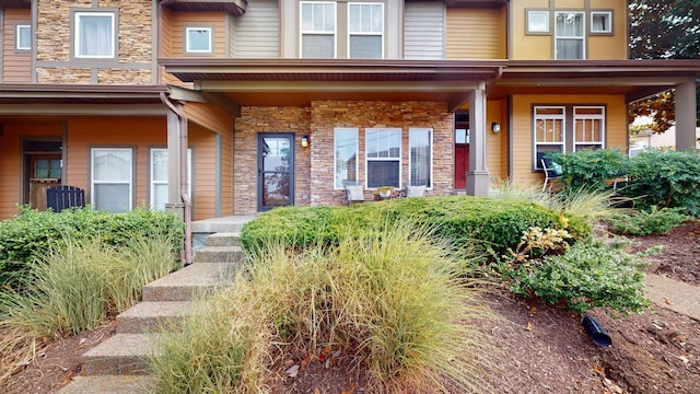 property entrance with stone siding and covered porch