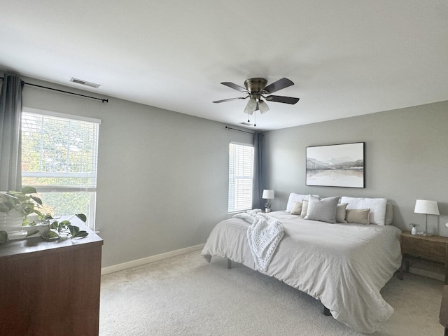 carpeted bedroom featuring a ceiling fan, baseboards, and visible vents