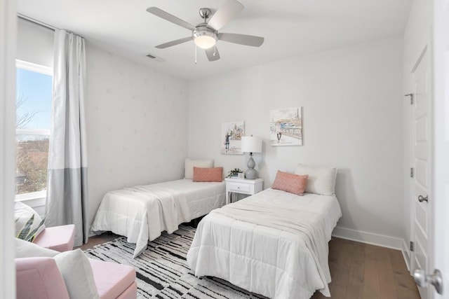 bedroom featuring visible vents, ceiling fan, baseboards, and wood finished floors