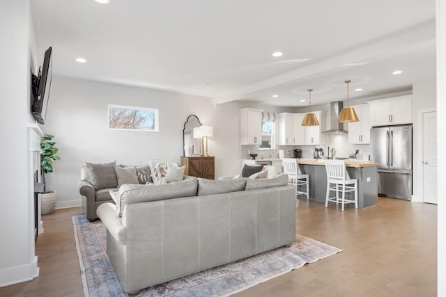 living room with recessed lighting, baseboards, and wood finished floors