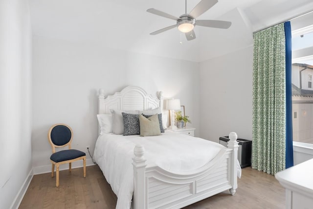 bedroom with a ceiling fan, light wood-type flooring, and baseboards