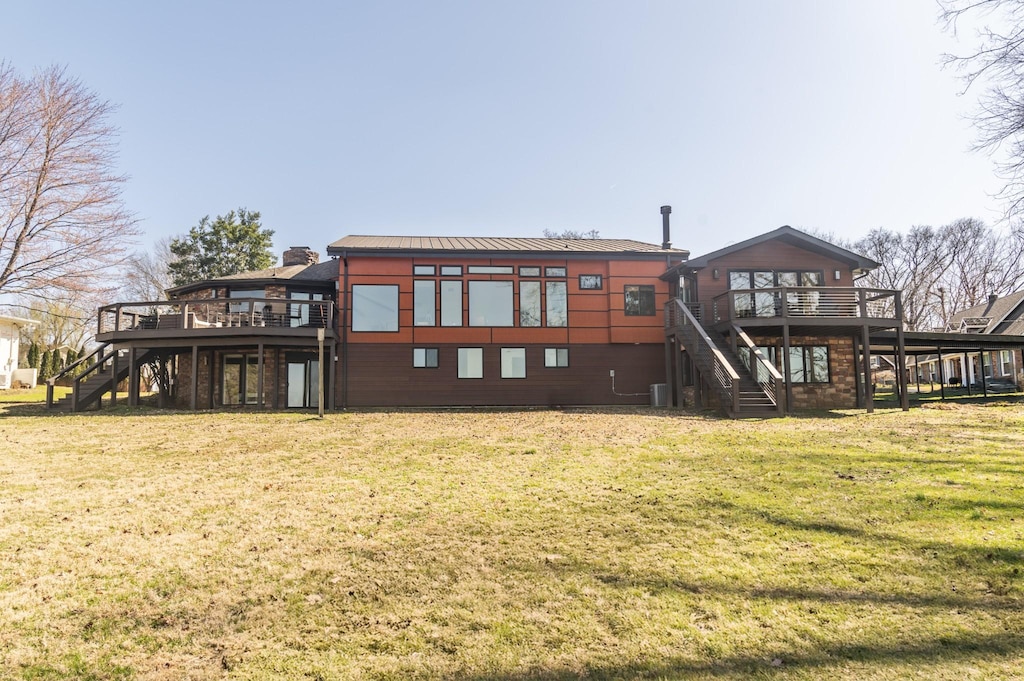 rear view of property featuring stairs, a yard, and a wooden deck