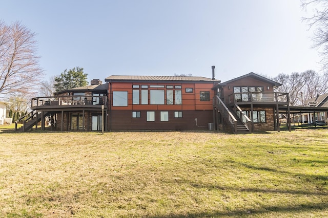 rear view of property featuring stairs, a yard, and a wooden deck