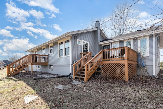 rear view of property featuring a wooden deck, a chimney, and stairs