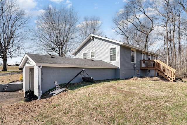 view of home's exterior featuring a yard, roof with shingles, concrete block siding, and stairway