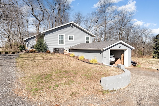 view of home's exterior with a garage, a lawn, and driveway