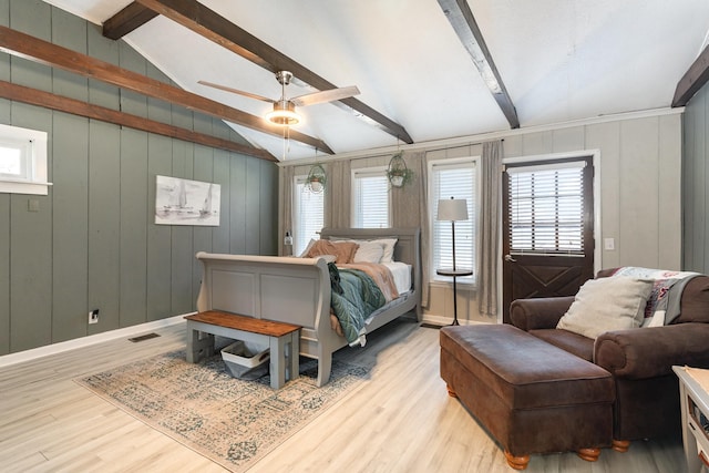 bedroom featuring multiple windows, lofted ceiling with beams, baseboards, and wood finished floors