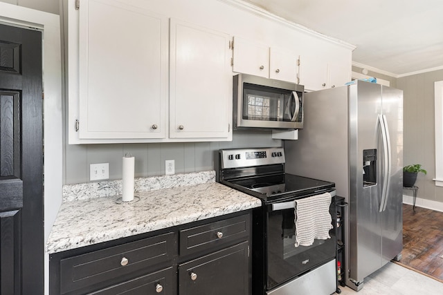 kitchen with wood finished floors, dark cabinetry, stainless steel appliances, white cabinets, and crown molding