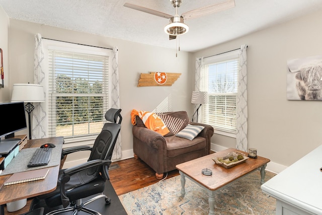 office space featuring ceiling fan, wood finished floors, baseboards, and a textured ceiling