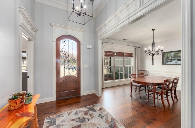 foyer entrance with an inviting chandelier, wood finished floors, crown molding, and arched walkways