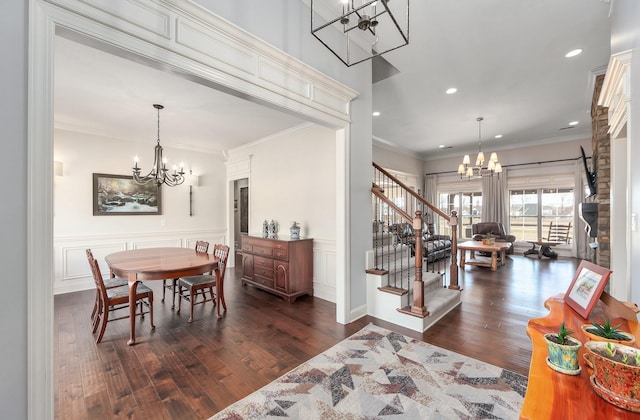 dining area featuring stairway, an inviting chandelier, dark wood finished floors, and crown molding