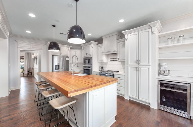 kitchen with a sink, wine cooler, appliances with stainless steel finishes, butcher block counters, and crown molding