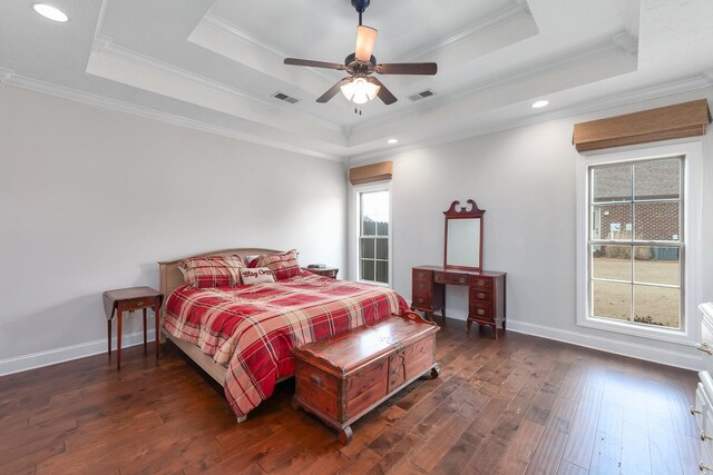 bedroom with visible vents, a raised ceiling, and wood finished floors