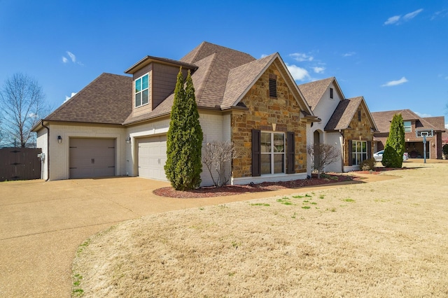 view of front facade featuring driveway, stone siding, roof with shingles, an attached garage, and brick siding