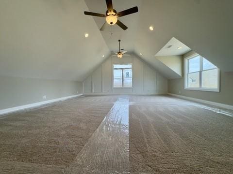 additional living space with baseboards, lofted ceiling, carpet, and ceiling fan