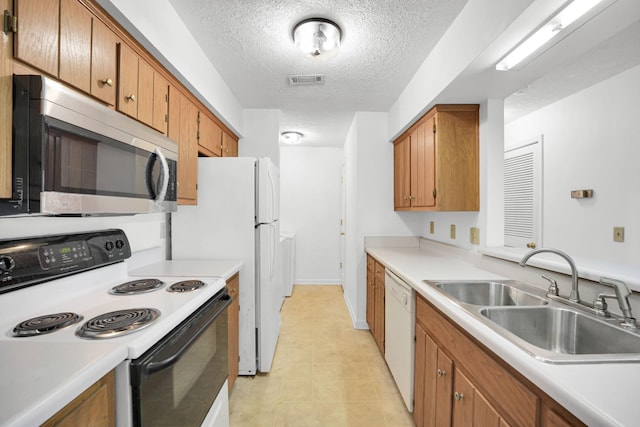 kitchen featuring white appliances, visible vents, a sink, light countertops, and brown cabinets