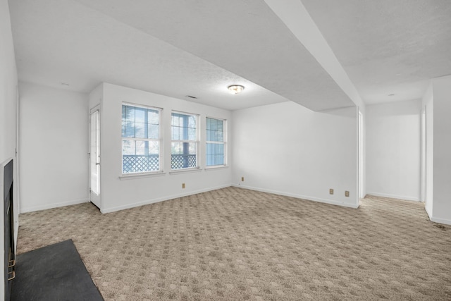 unfurnished living room with visible vents, carpet, baseboards, and a textured ceiling