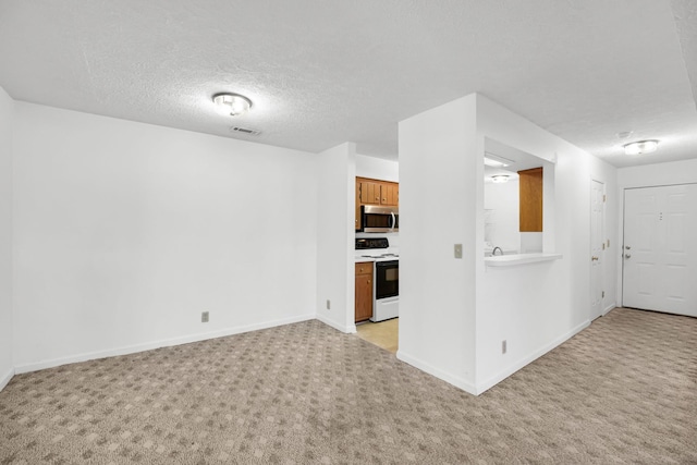 interior space featuring stainless steel microwave, light colored carpet, visible vents, and electric range oven