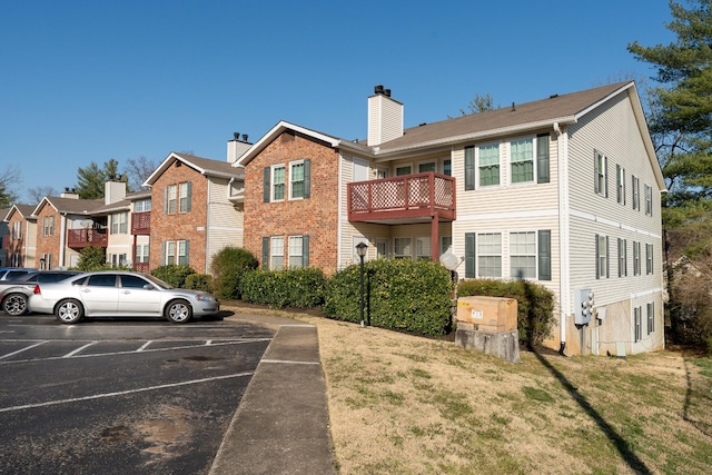 exterior space with a yard, a residential view, uncovered parking, and a chimney