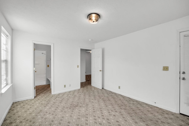 unfurnished bedroom featuring multiple windows, baseboards, and carpet floors